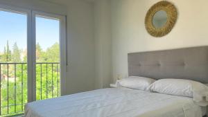 a bedroom with a bed with a mirror and a balcony at El puente de San Martín con parking gratis in Toledo