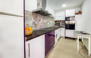 a kitchen with purple and white cabinets and a sink at Nice Home In El Ventorrillo With Outdoor Swimming Pool, Wifi And Private Swimming Pool in Belicena