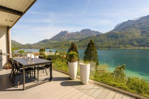 a balcony with a table and a view of a lake at Les Eaux Cristallines de Bredannaz, unique vue lac 6p LLA Selections by Location lac Annecy in Doussard