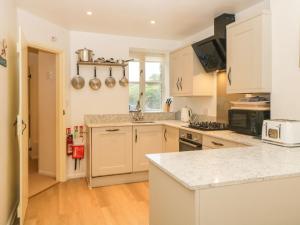 a kitchen with white cabinets and a counter top at Blackberry Cottage in Kingsbridge