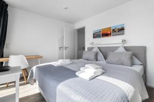 una camera bianca con letto blu e cuscini bianchi di Seestern a Olpenitz