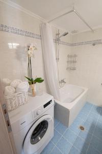 a bathroom with a washing machine and a bath tub at Irena House by RentalsPro - Dionisiou Halkidiki in Zográfos