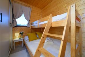 a bedroom with two bunk beds in a wooden cabin at Zielona Trawa in Bobolin
