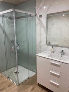 uma casa de banho com um chuveiro e um lavatório. em Apartamento Blanco em Mazaricos