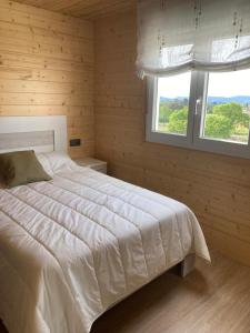 um quarto com uma grande cama branca e 2 janelas em Apartamento Blanco em Mazaricos