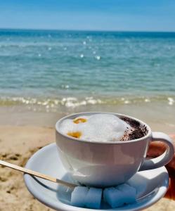 uma chávena de café num prato na praia em Renaissance em Bou Ficha