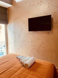 1 dormitorio con TV y 3 toallas enrolladas en una cama en MAISON LILLY, en Nápoles