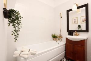 a bathroom with a tub and a sink and a mirror at Chic Concept Studio in Bucharest