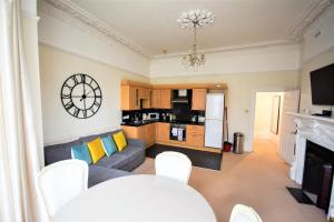 een woonkamer met een bank en een tafel bij Peaceful & Pretty 2 bedroom flat near Clifton in Bristol