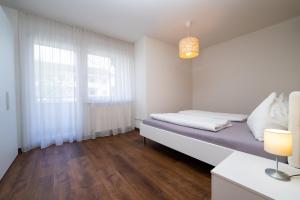 Camera bianca con letto e finestra di Appartament Emma a Brunico