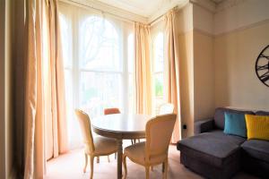 a living room with a table and chairs and a couch at Peaceful & Pretty 2 bedroom flat near Clifton in Bristol