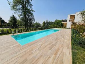 een zwembad met een houten terras en een hek bij Il Diamante Blu-by Goccia di Lago in San Martino della Battaglia