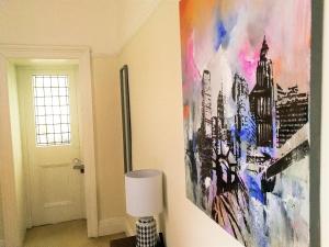 un dipinto appeso a un muro accanto a una lampada di Peaceful & Pretty 2 bedroom flat near Clifton a Bristol