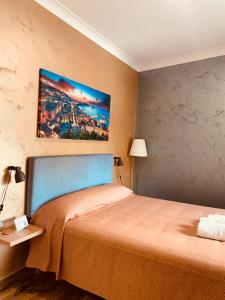 1 dormitorio con 1 cama y una pintura en la pared en MAISON LILLY, en Nápoles