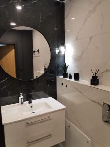 a bathroom with a white sink and a mirror at Apartament Gór-Ski Saneczkowa in Karpacz