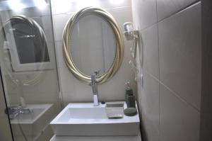 La salle de bains est pourvue d'un lavabo et d'un miroir. dans l'établissement Loft Matina, à Nauplie