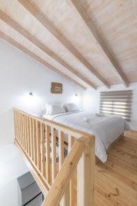 een slaapkamer met een groot bed en een houten trap bij Loft Matina in Nafplio