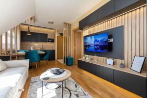 a living room with a couch and a tv on a wall at Jupiter in Zlatibor