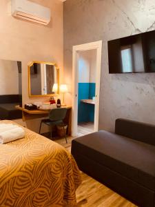 1 dormitorio con cama, escritorio y espejo en MAISON LILLY, en Nápoles