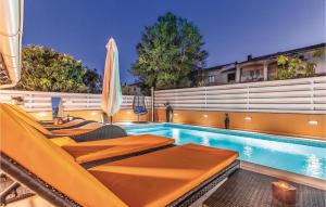 una piscina con tumbonas y sombrilla en Nice Home In Banjole With Jacuzzi, en Banjole