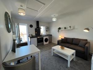 een woonkamer met een bank en een tafel bij Flat 2 High Street Apartments, One Bed in Wellington