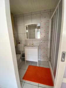 a bathroom with a sink and a toilet and a mirror at Do-Ti Apartmanház Balatonlelle in Balatonlelle