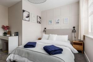 a bedroom with a bed with two blue towels on it at Modern 2 bed, cliff top & parking, F6 in Southbourne