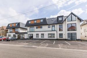a large white building with a parking lot at Modern 2 bed, cliff top & parking, F6 in Southbourne