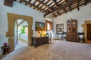 a large living room with an archway and a room with a table at Canapost in Peratallada