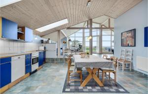 una cucina con armadi blu e tavolo con sedie di Pet Friendly Home In Grlev With Kitchen a Reersø