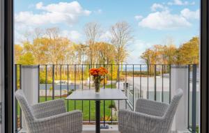 ein Balkon mit Stühlen und einem Tisch mit einer Blumenvase in der Unterkunft Baltischer Hof Apartment 59 in Boltenhagen