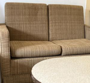 un divano marrone seduto accanto a un tavolo di Country Side Modern Concept Cottage a Bentong
