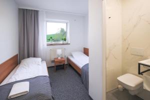 ein Hotelzimmer mit 2 Betten und einem WC in der Unterkunft Hotel pod Wieliczką in Gdów
