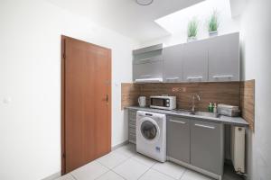 eine Küche mit einer Waschmaschine und einem Waschbecken in der Unterkunft Hotel pod Wieliczką in Gdów