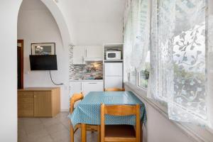 een eetkamer met een tafel en stoelen en een keuken bij Monolocale 12 in Pietra Ligure