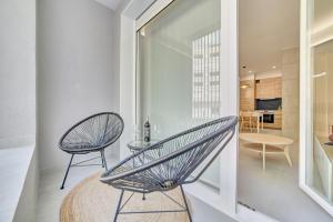 una silla y una mesa en una habitación con ventana en Apartamentos Pamplona Confort by Clabao, en Pamplona