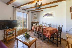 a dining room with a table and a television at Carrebaix IV in Orba