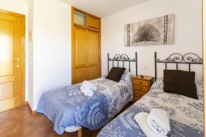 a bedroom with two beds with blue and white sheets at Carrebaix IV in Orba