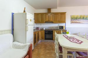 Il comprend une cuisine équipée d'un réfrigérateur blanc et d'une table avec des chaises. dans l'établissement Carrebaix V, à Orba