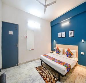 een slaapkamer met een groot bed met een blauwe muur bij FabHotel Silverkey Kalighat in Calcutta