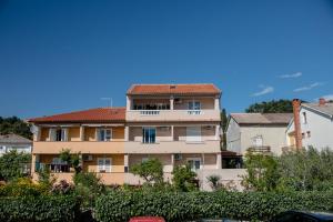 a large apartment building with a red roof at Apartments Luka in Rab