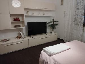 una sala de estar con TV en un armario blanco en benny house en Nettuno