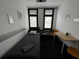 Cette chambre comprend un lit, une table et des fenêtres. dans l'établissement Aleja "Solidarności", à Varsovie