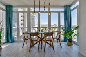 een eetkamer met een tafel en stoelen en grote ramen bij Apartment EntreDosAguas in Calpe