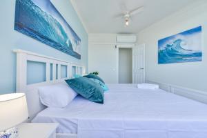 een witte slaapkamer met een groot bed met blauwe kussens bij Apartment EntreDosAguas in Calpe