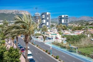 een stadsstraat met palmbomen en gebouwen bij Apartment EntreDosAguas in Calpe