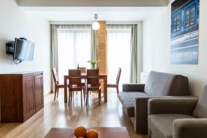ein Wohnzimmer mit einem Sofa und einem Tisch mit Stühlen in der Unterkunft udanypobyt Apartamenty Smrekowa in Zakopane