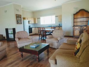 Sala de estar con 2 sofás y mesa en Matalatala Wildlife Lodge, en Roodeplaat