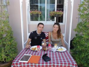a man and woman sitting at a table eating food at Sorn Waree Home place in Kanchanaburi City