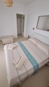 uma grande cama branca com duas toalhas dobráveis em Lotto 16 em Olbia
